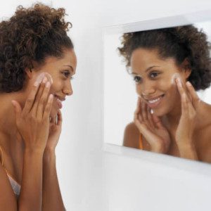 black-woman-looking-in-mirror-face-cream