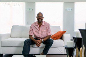 Smiling Black man sitting on sofa