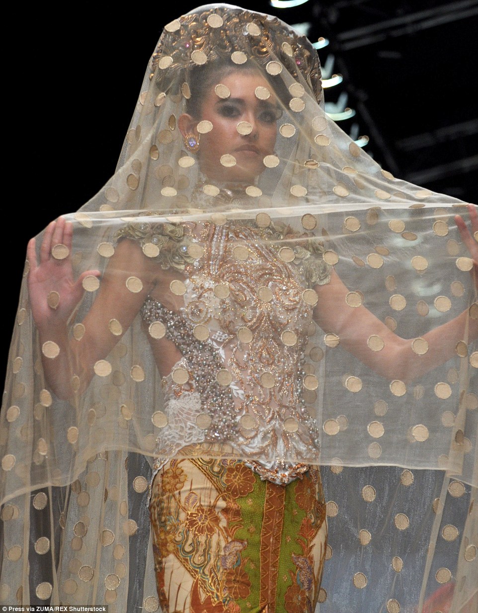 2DDF608500000578-3293566-A_model_wears_a_gold_medallion_veil_over_her_printed_dress-m-55_1446052282050