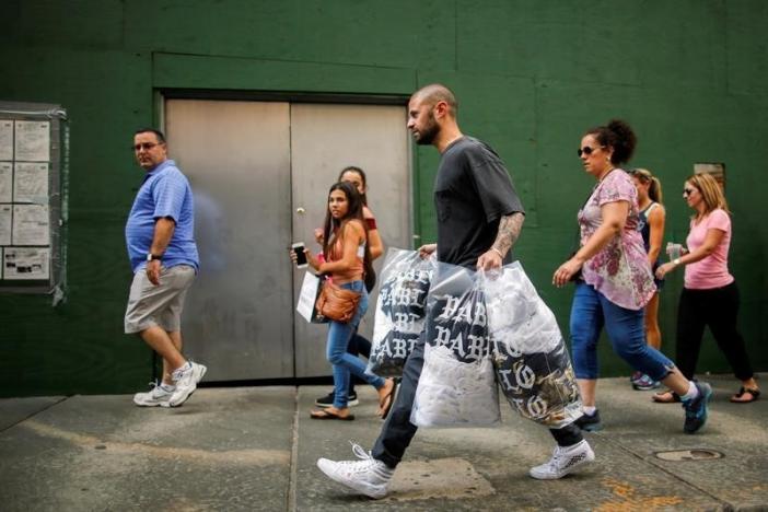 A shopper carries "The Life of Pablo" merchandise after visiting a pop up store featuring fashion by Kanye West in Manhattan, New York, U.S., August 19, 2016. REUTERS/Eduardo Munoz