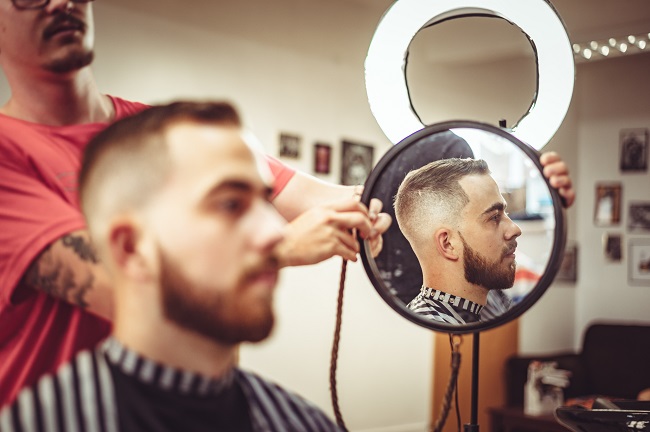 Man checking mirror after cutting his hair