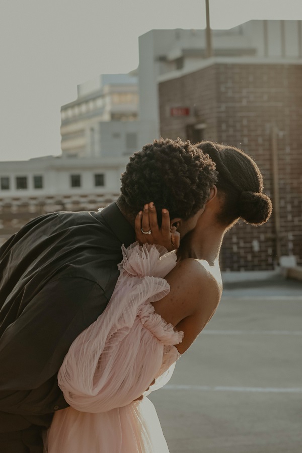 Photo of African American bride and groom wearing wedding dress and suit