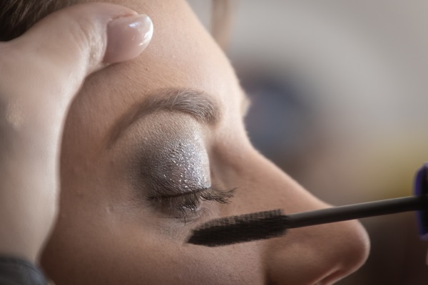 Photo of a woman doing eye makeup