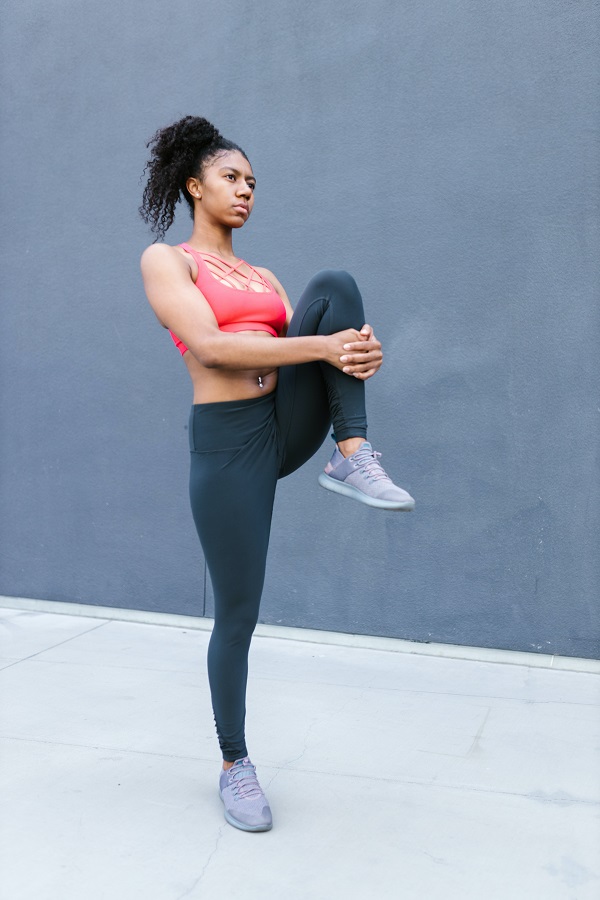 Photo of woman exercising and wearing gym clothes and sneakers