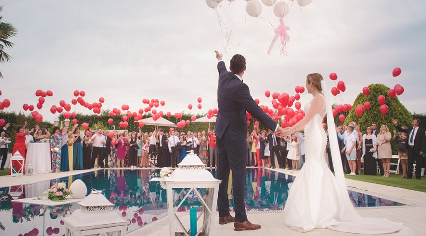 Photo of bride and groom with colorful balloons