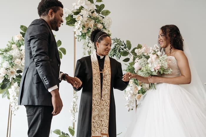 photo of African American bride and groom at the alter with a pastor - Fashion Police NG