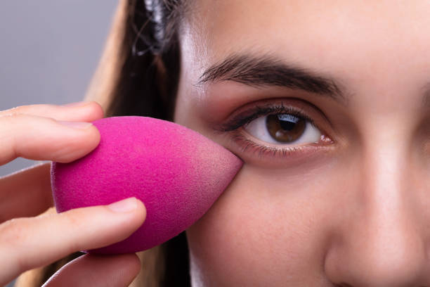 Pretty Woman Using Pink Sponge Blender Make Up Tool On Face
