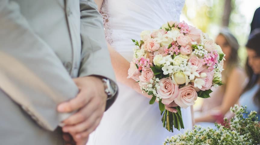 Photo of bride and groom with wedding flowers