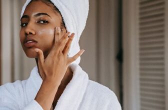 African American woman moisturizing her skin