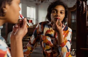 Photo of African American woman applying lipstick - Fashion Police Nigeria