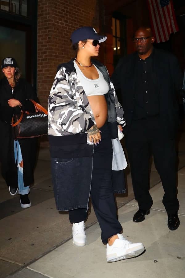 Rihanna jetting out of NYC wearing a white Loewe bralette, black low-rise jogger sweatpants, a black-and-white camo jacket, and white sneakers photo - Fashion Police Nigeria