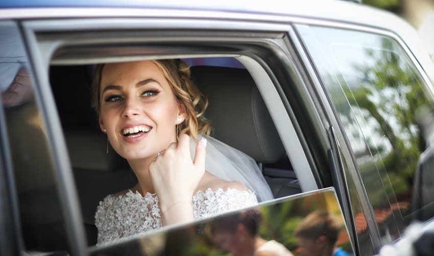 Photo of a bride smiling in a car - Fashion Police Nigeria