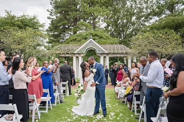 bride and groom kissing at an outdoor wedding ceremony photo - Fashion Police Nigeria