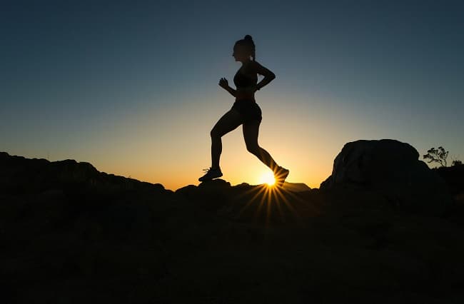 silhouette of man jumping on rocky mountain during sunset photo - Fashion Police Nigeria