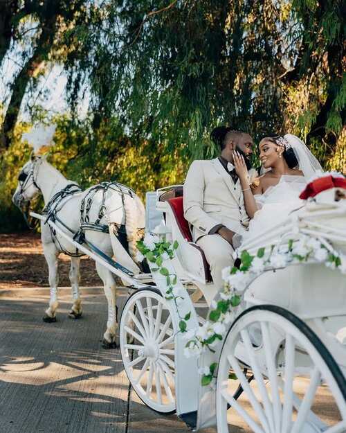 Bride and groom riding in a chariot after their vintage country wedding in Nigeria - Fashion Police Nigeria