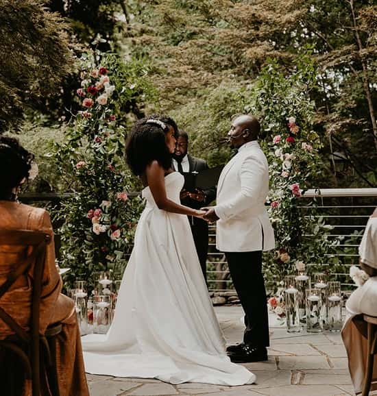 Photo of African American bride and groom getting married in matching white wedding gown and pantsuit - Fashion Police Nigeria