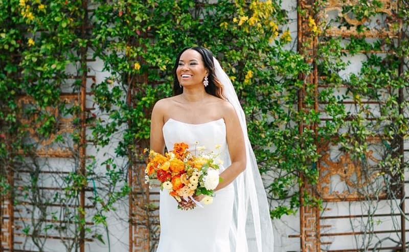 Photo of a beautiful bride wearing a wedding gown and veil, and also carrying bouquet - Fashion Police Nigeria