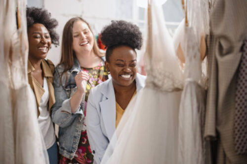 Female friends looking at a wedding dress on a rack - Fashion Police Nigeria
