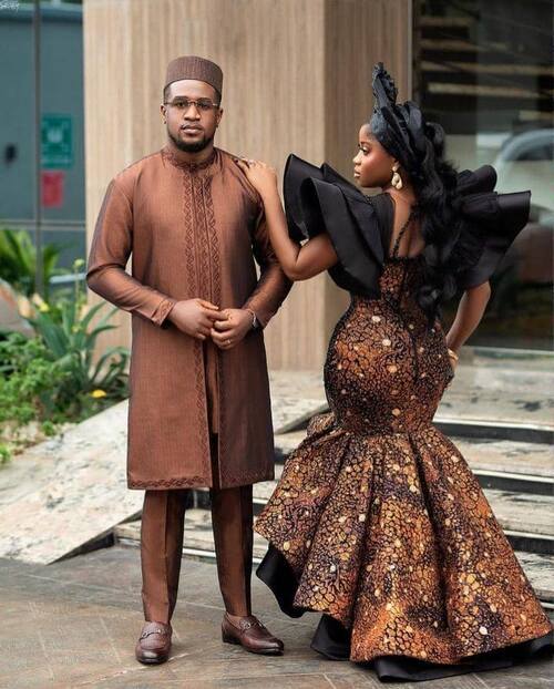 A photo of a Nigerian wedding guest couple attending a wedding in a matching traditional attire 