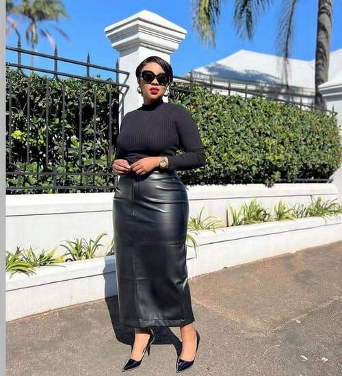 African American woman wearing a vintage French girl fashion, featuring a turtleneck bobycon top, leather ankle length skirt and high heels