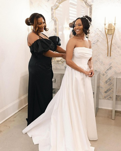 A beautiful photo of mother dressing up her bride daughter on her wedding day