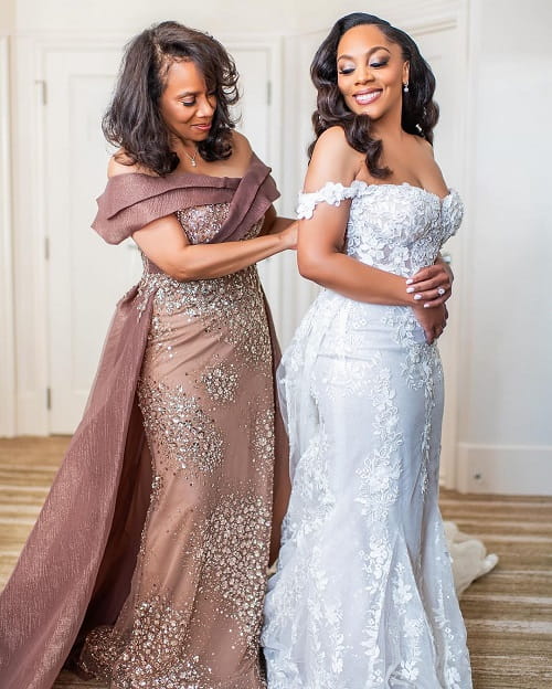 A beautiful photo of mother dressing up her bride daughter on her wedding day