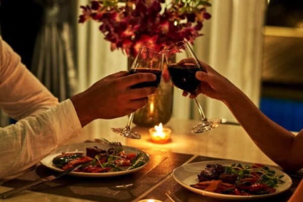 Photo of a couple making a toast on a romantic dinner date - Fashion Police Nigeria