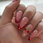 Photo of red French nails with cherry gem accents
