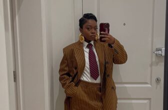 Photo of a lady wearing a brown pinstripe suit and posing in a car - Fashion Police Nigeria