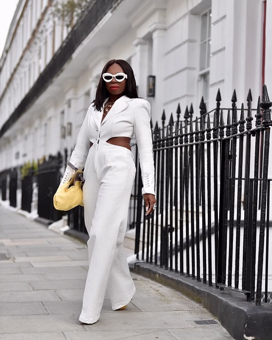 Photo of a black African American woman wearing white with a yellow bag - Fashion Police Nigeria