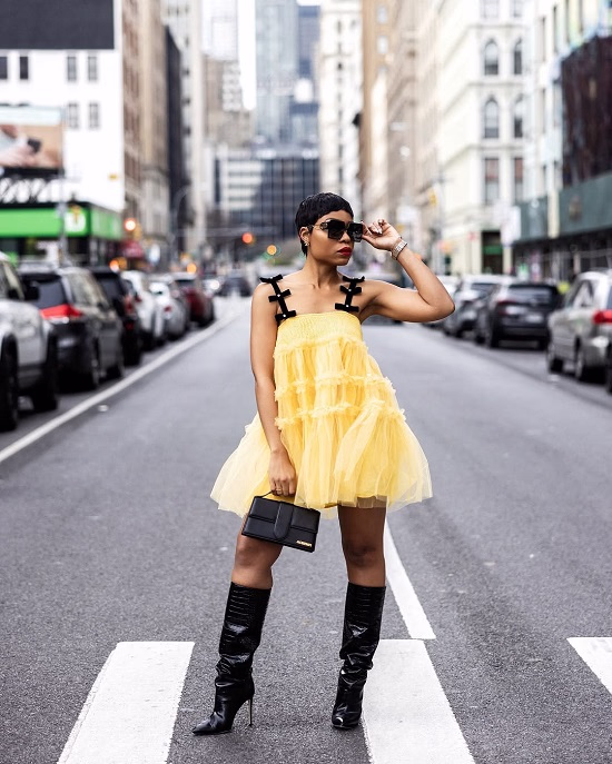Photo of a woman wearing a yellow mini dress with a black thigh high boots - Fashion Police Nigeria