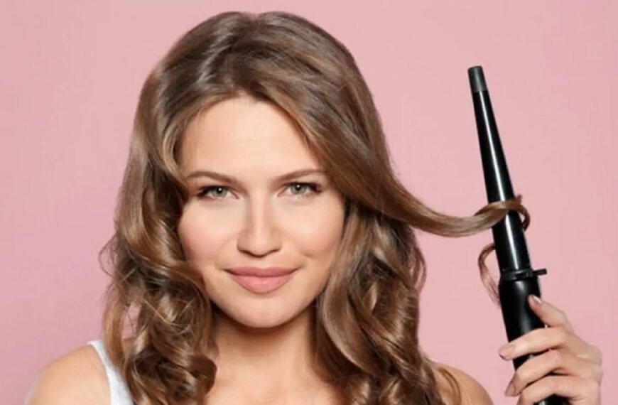 photo of a lady using a curling wand on her hair- Fashion Police Nigeria