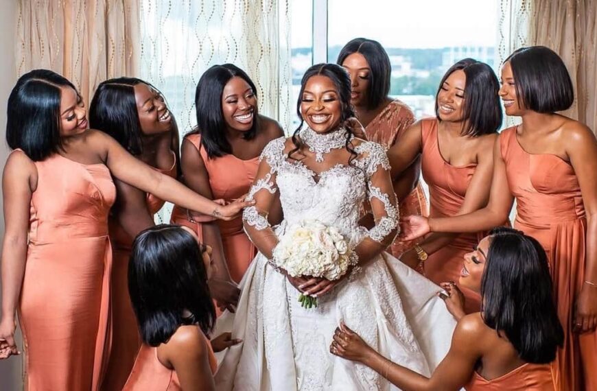 Photo of bridesmaids with the brides smiling and admiring the bride's wedding dress - Fashion Police Nigeria