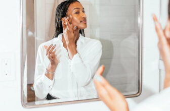 photo of African woman standing by the mirror in the bathroom - Fashion Police Nigeria