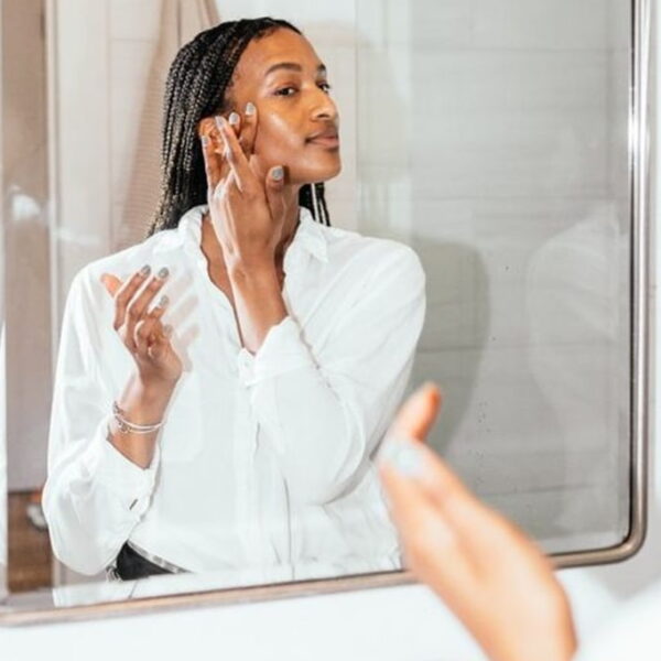 photo of African woman standing by the mirror in the bathroom - Fashion Police Nigeria