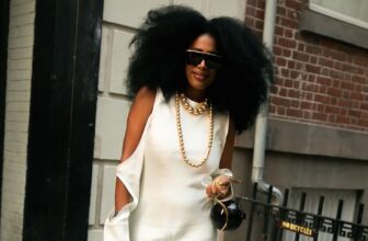 Photo of a beautiful black woman wearing a satin sleeveless dress and her hair in afro walking the street
