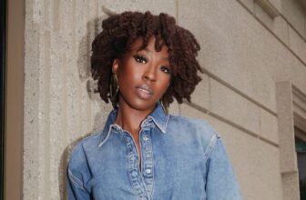 Photo of a beautiful African American woman wearing denim on denim and curly hair while leaning against the wall - Fashion Police Nigeria