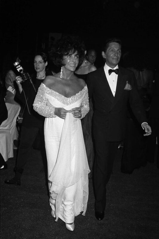 Elizabeth is photographed with Valentino Garavani at a gala celebrating Valentino's 30th anniversary in 1991 - Fashion Police Nigeria