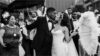 Black and white photo of bride and groom kissing in front of the wedding guests - Fashion Police Nigeria