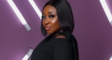 Ini Edo Poses In Turtleneck Top, Mini Leather Skirt & Thigh-High Booties
