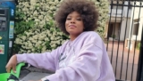 Yemi Alade Rides a Bicycle in Paris in a Pink Sweatshirt, Tiny Short Pants, and Sneakers
